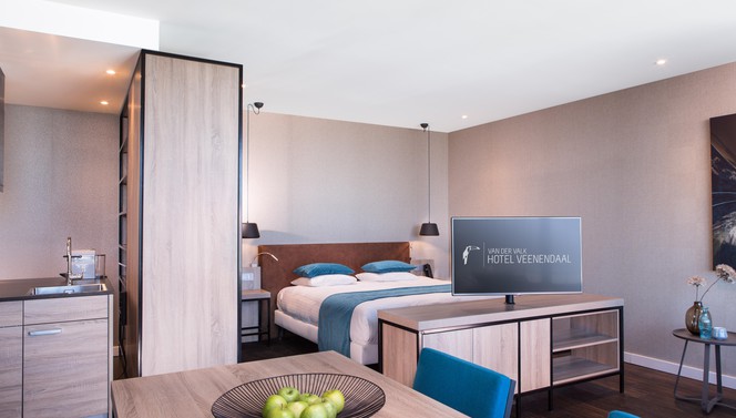 Slaapkamer met kingsize bed in loft Hotel Veenendaal